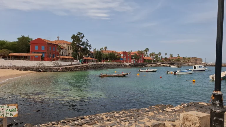 Vista sul mare dell’Isola di Gorée a Dakar in Senegal con barche tradizionali e case coloniali colorate