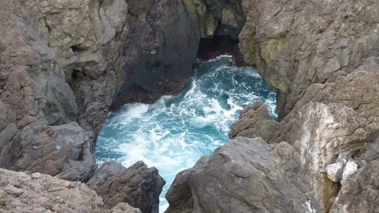 Piscine naturali di Porto Moniz a Madeira, formate da rocce vulcaniche scure e riempite di acqua marina cristallina, con onde dell'oceano che si infrangono sullo sfondo.
