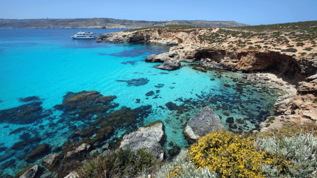 veduta della Blue Lagoon a Comino, Malta, acque turchesi e macchia mediterranea