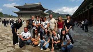 Gruppo di viaggiatori di Explora nel Mondo in posa davanti al padiglione principale del Palazzo Gyeongbokgung a Seoul, Corea del Sud.